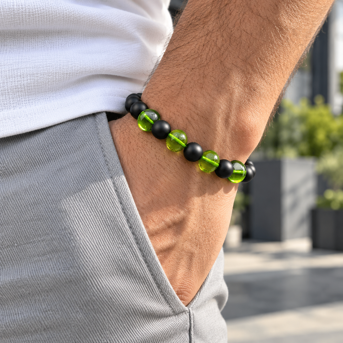 Mann trägt ein grünes Kehribar Armband aus echtem Bernstein mit schwarzen Onyx-Perlen am Handgelenk.